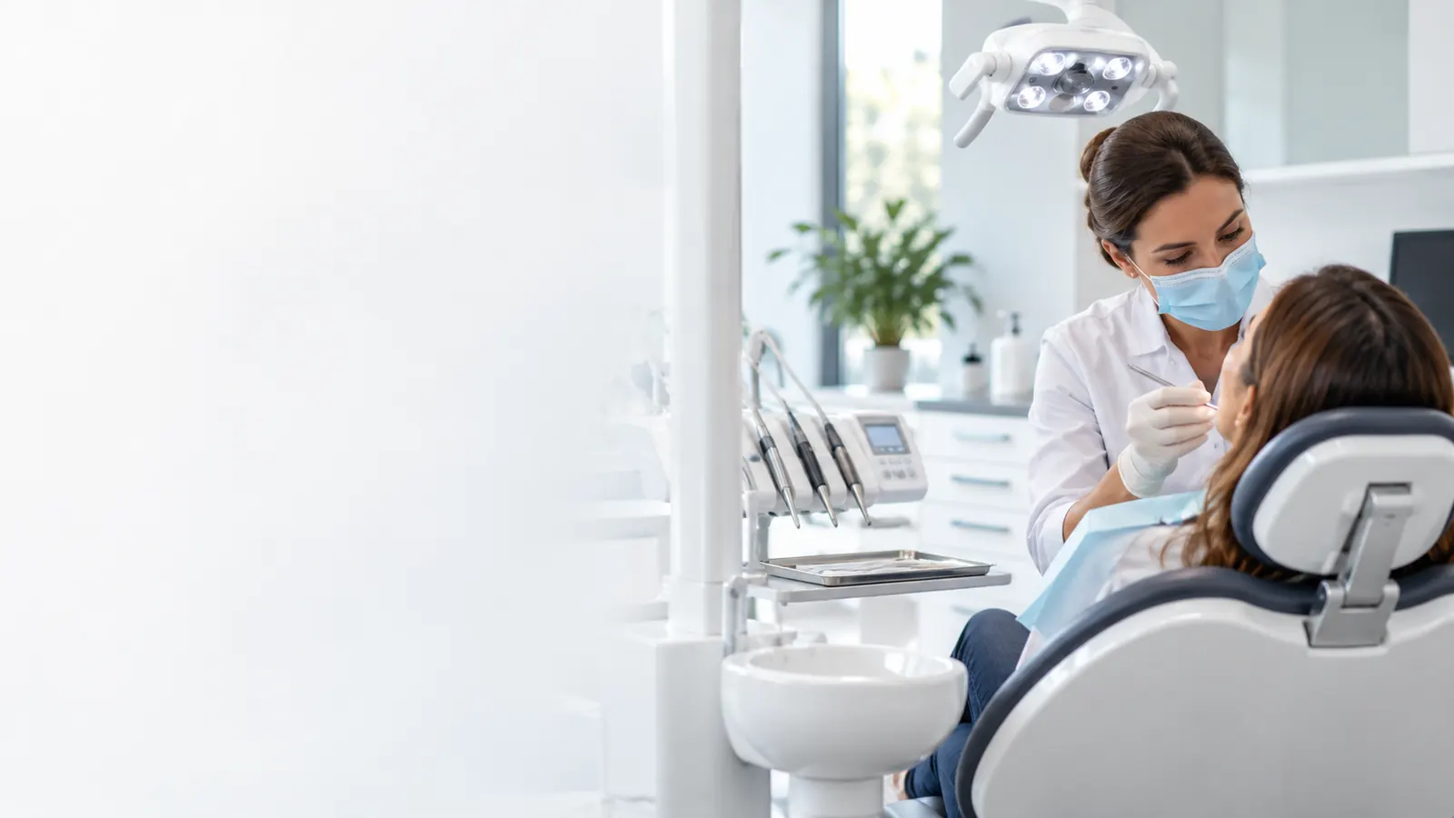 Dentista atendiendo a una paciente en una consulta dental moderna y luminosa